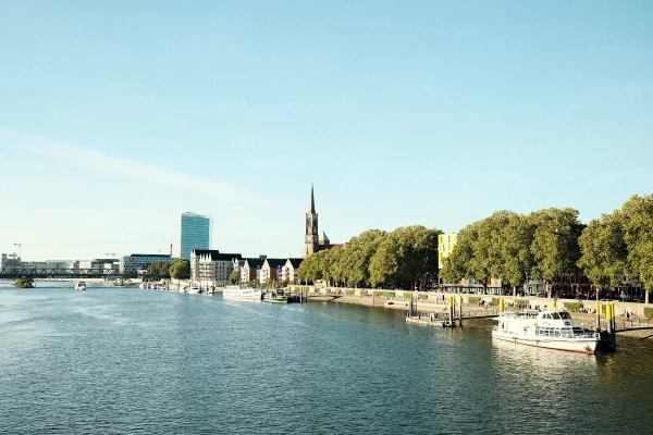 Detektei Bremen - Ein Gewässer mit einem Boot darin und Gebäuden im Hintergrund